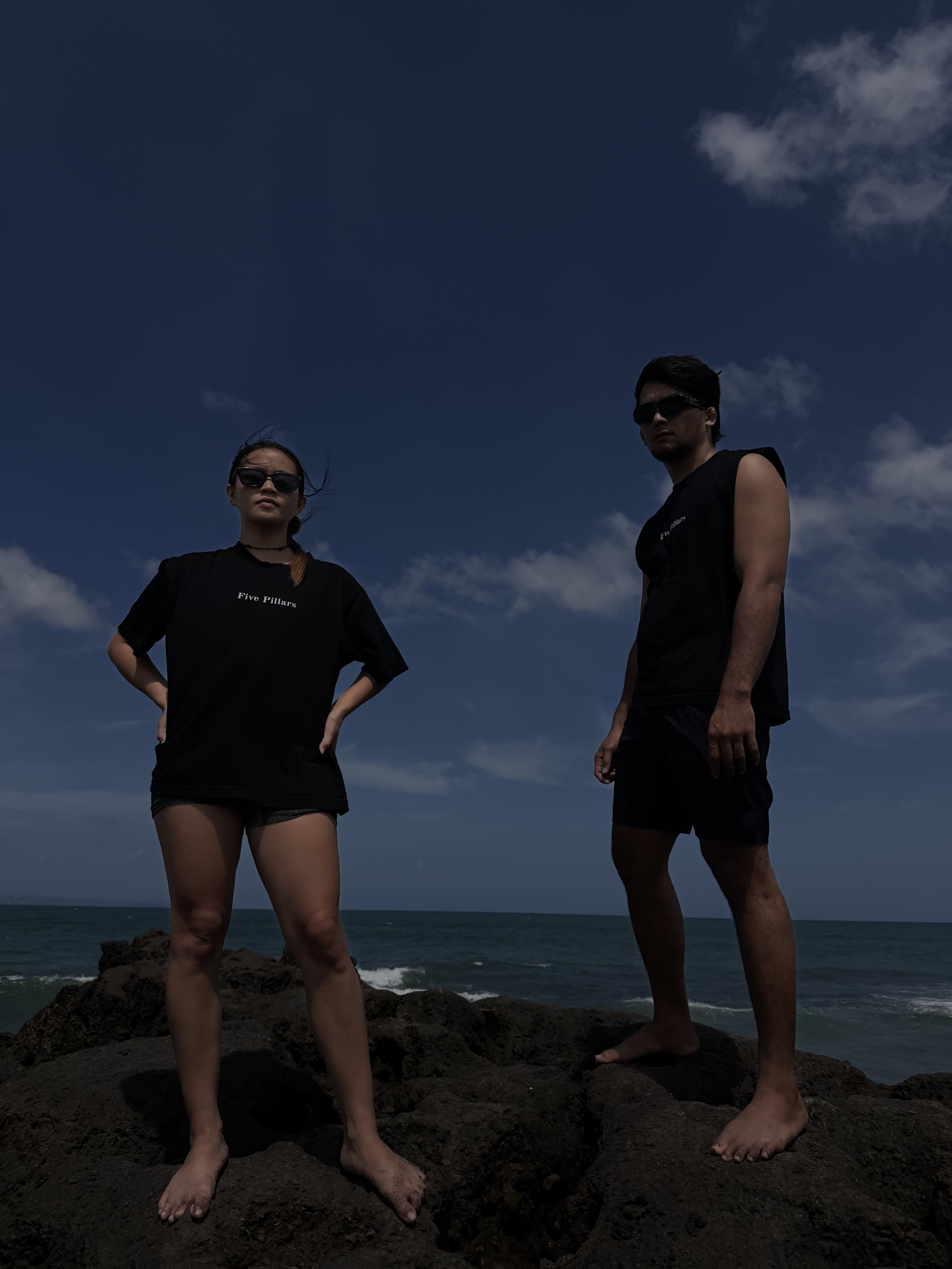 Brenda and Marck standing together on the rocks by the sea